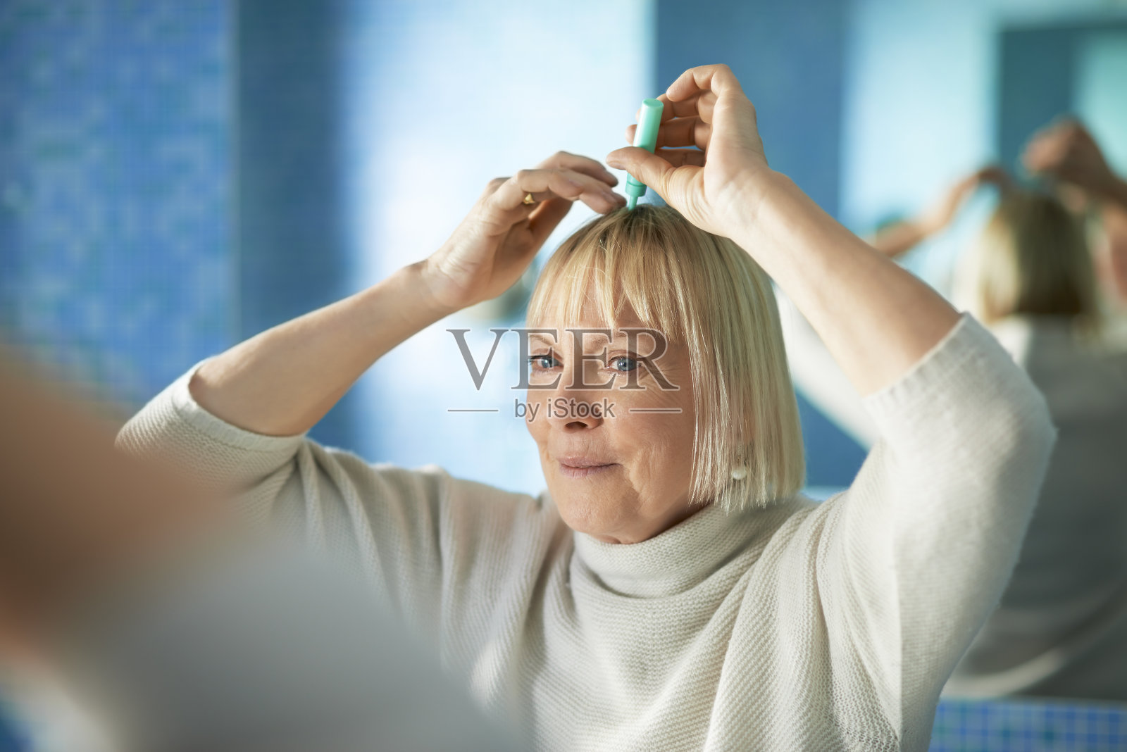 年长女性检查发际线是否有脱发照片摄影图片