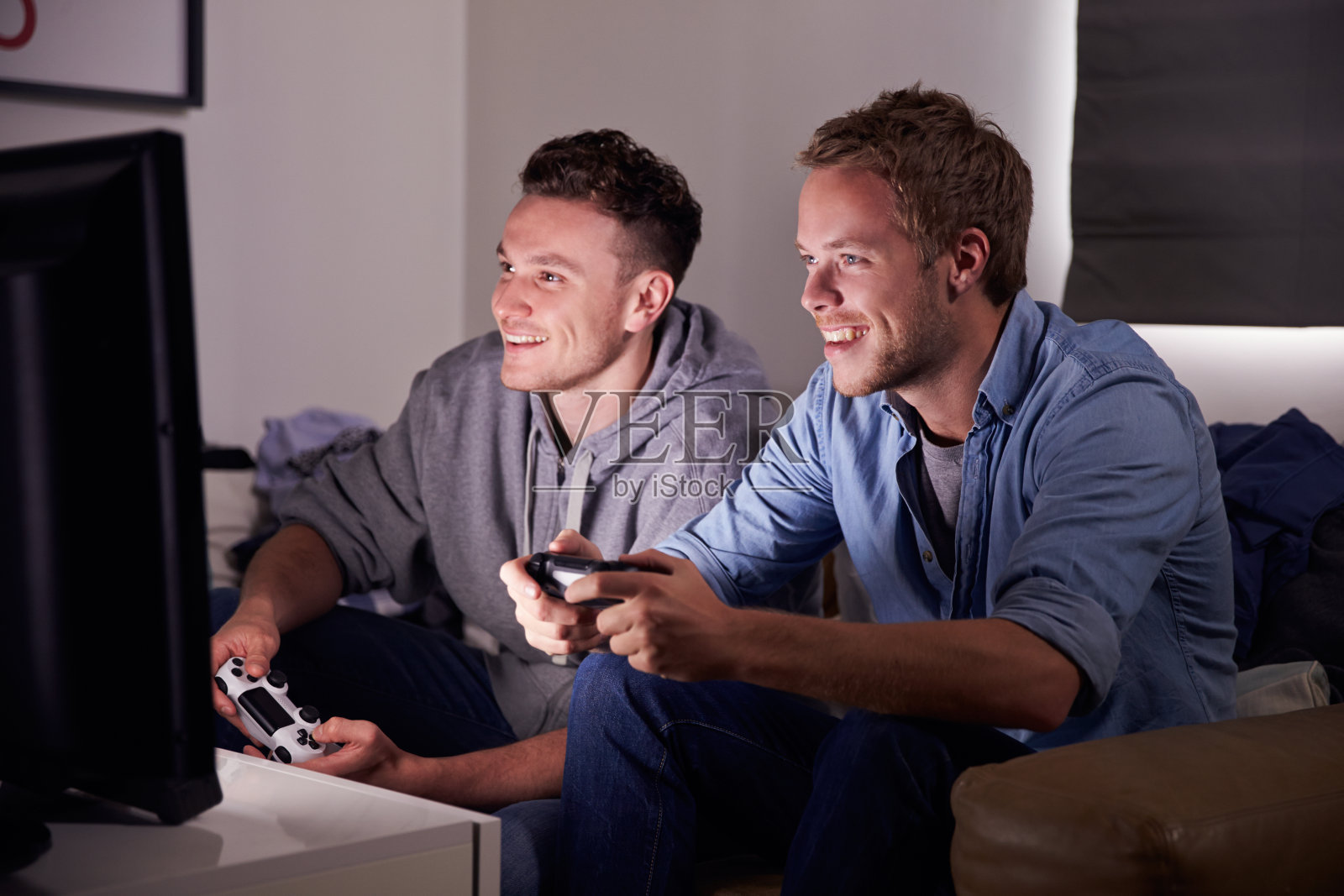 两个年轻人在家里玩电子游戏照片摄影图片
