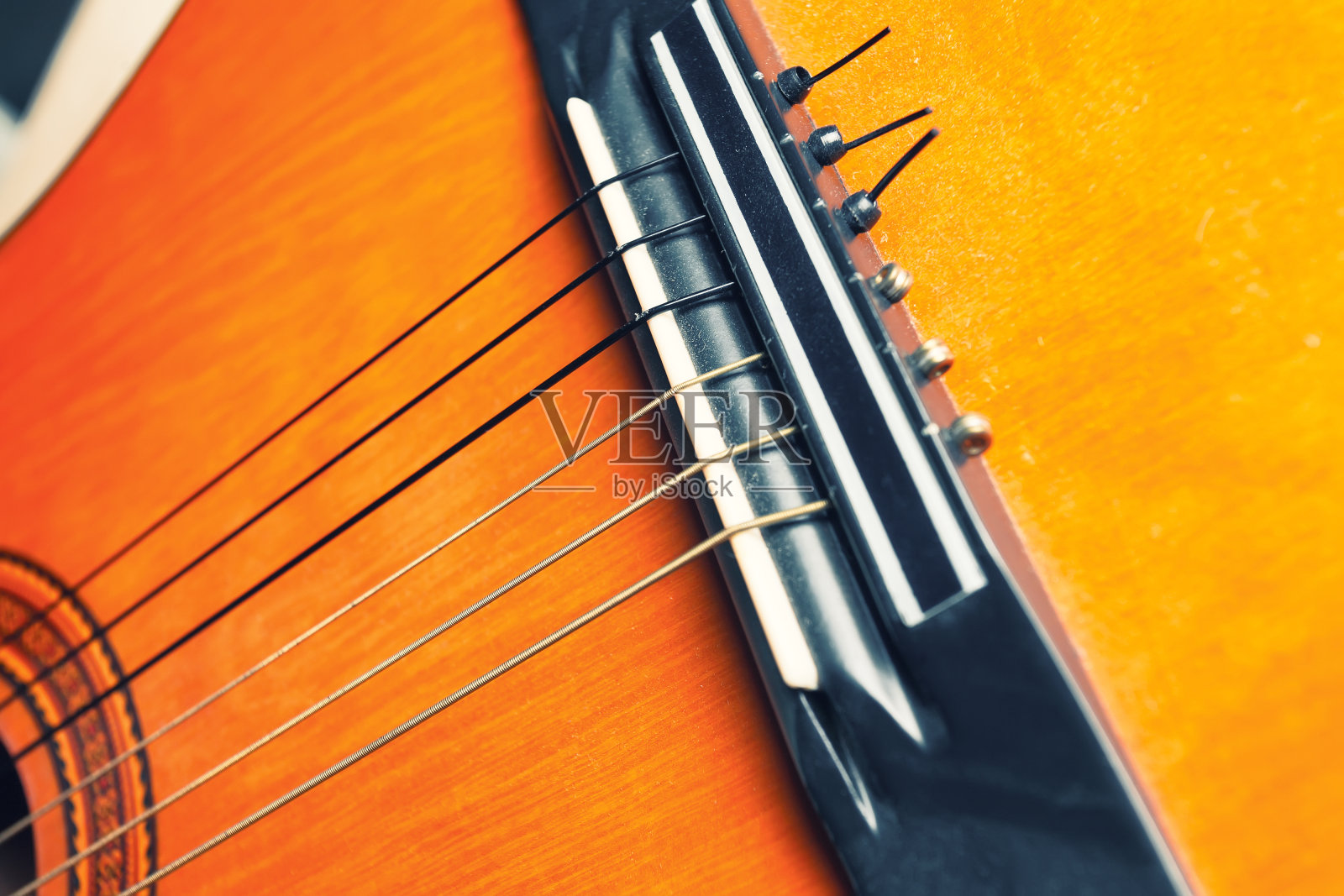 桥，弦和玫瑰的黄色和橙色的吉他。照片摄影图片
