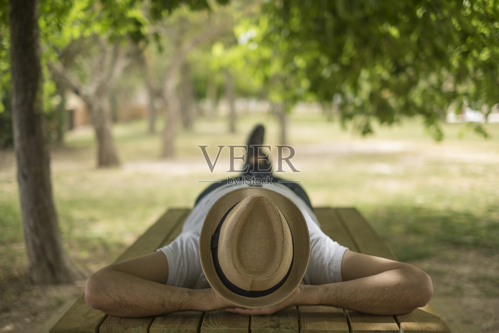安静的男孩戴着帽子躺在公园里照片摄影图片