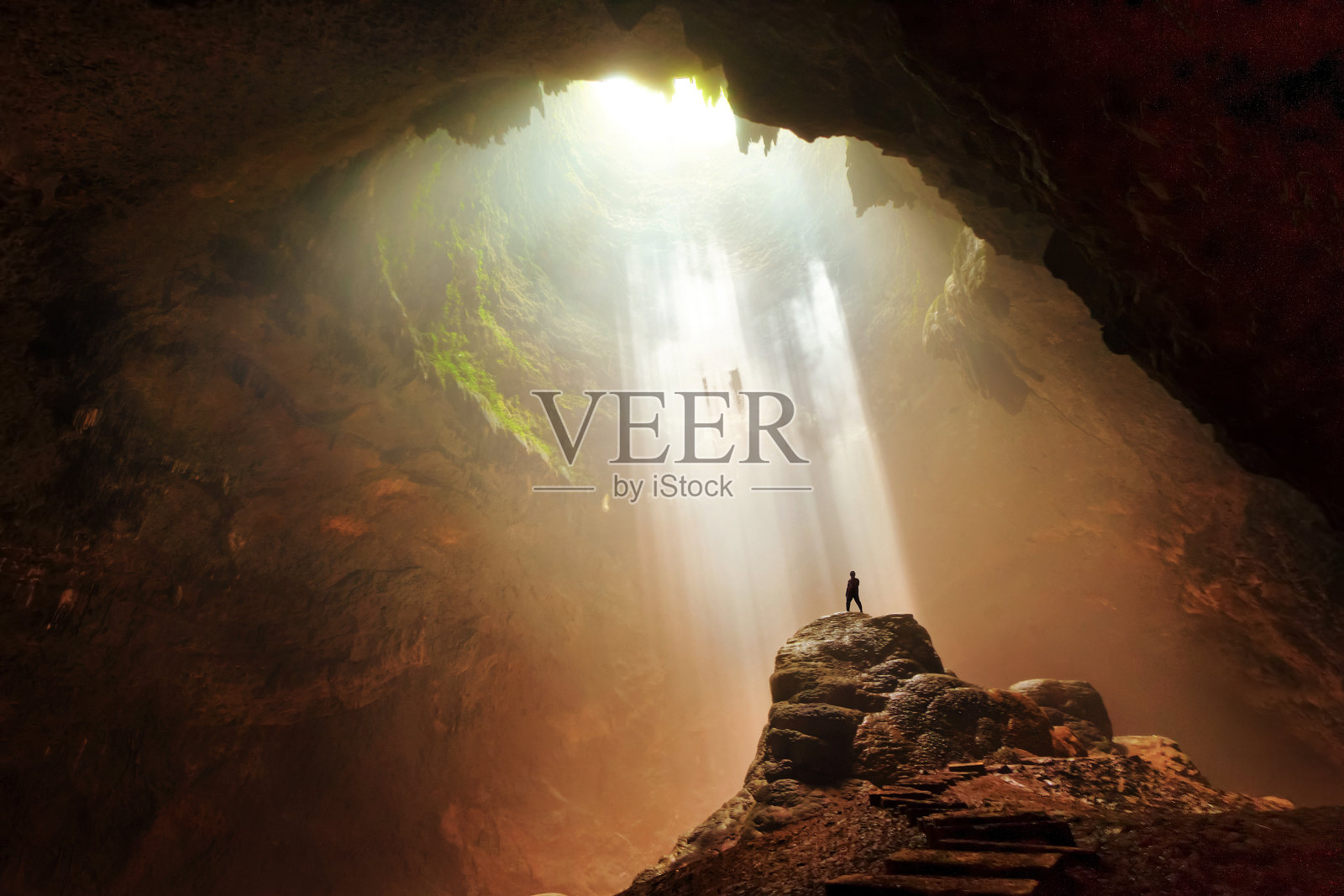 男子站在岩石地下洞穴光日惹印度尼西亚照片摄影图片