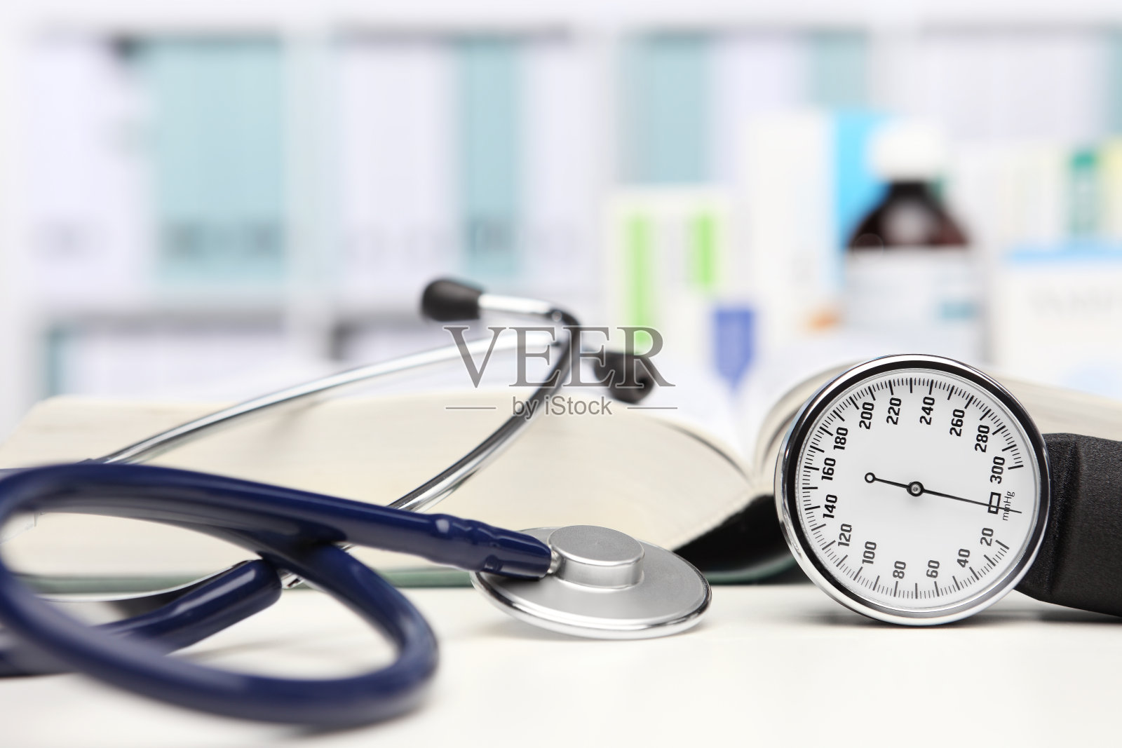 医生办公桌配有医疗设备、听诊器和临床血压计、血压测量、药物在后台照片摄影图片