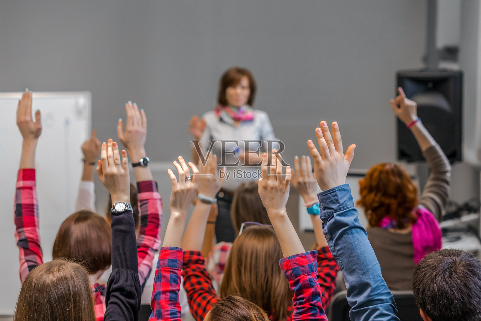 积极的学生举起手臂准备回答老师的问题照片摄影图片