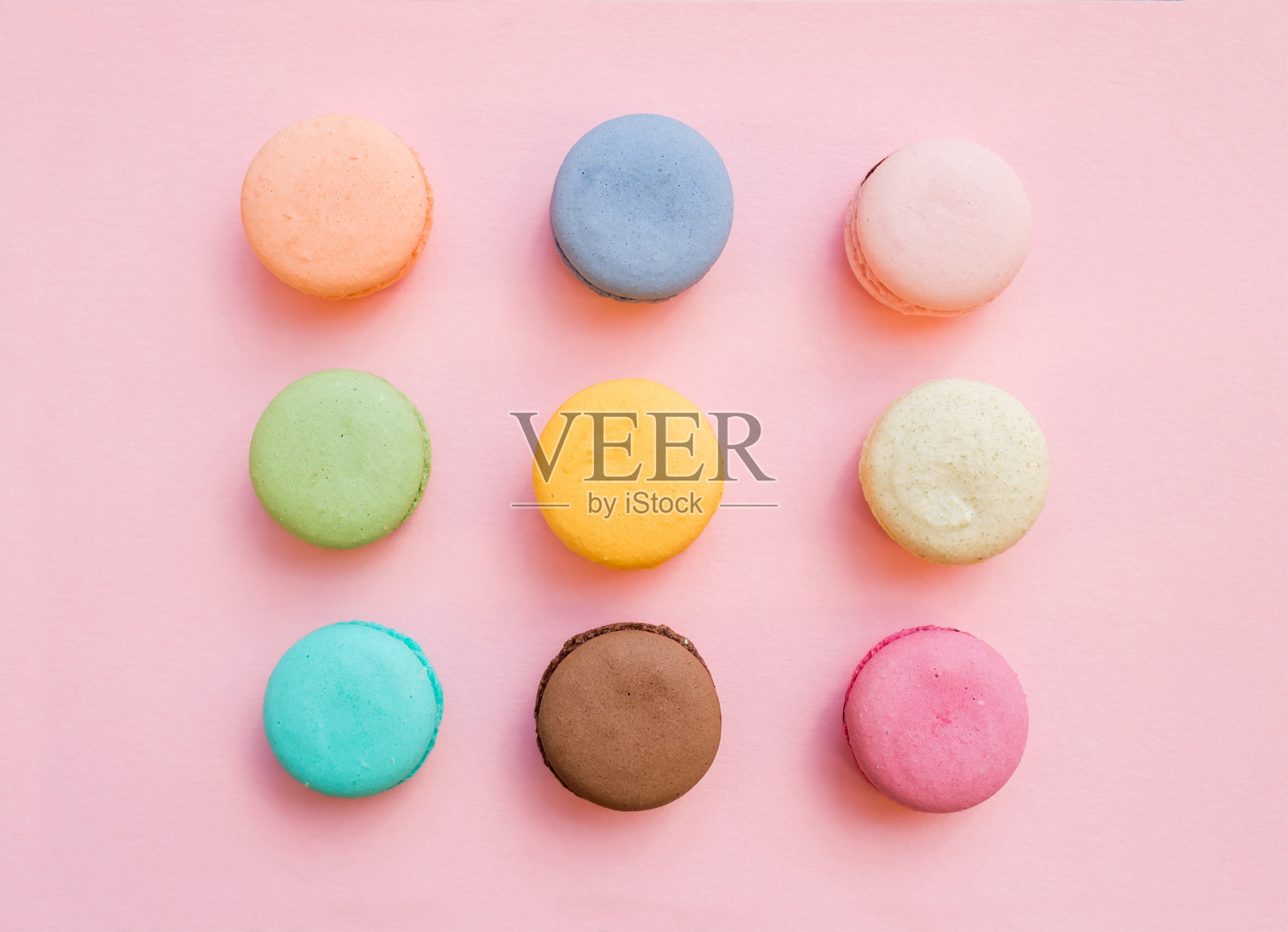 甜的彩色法国马卡龙饼干在淡粉色的背景照片摄影图片