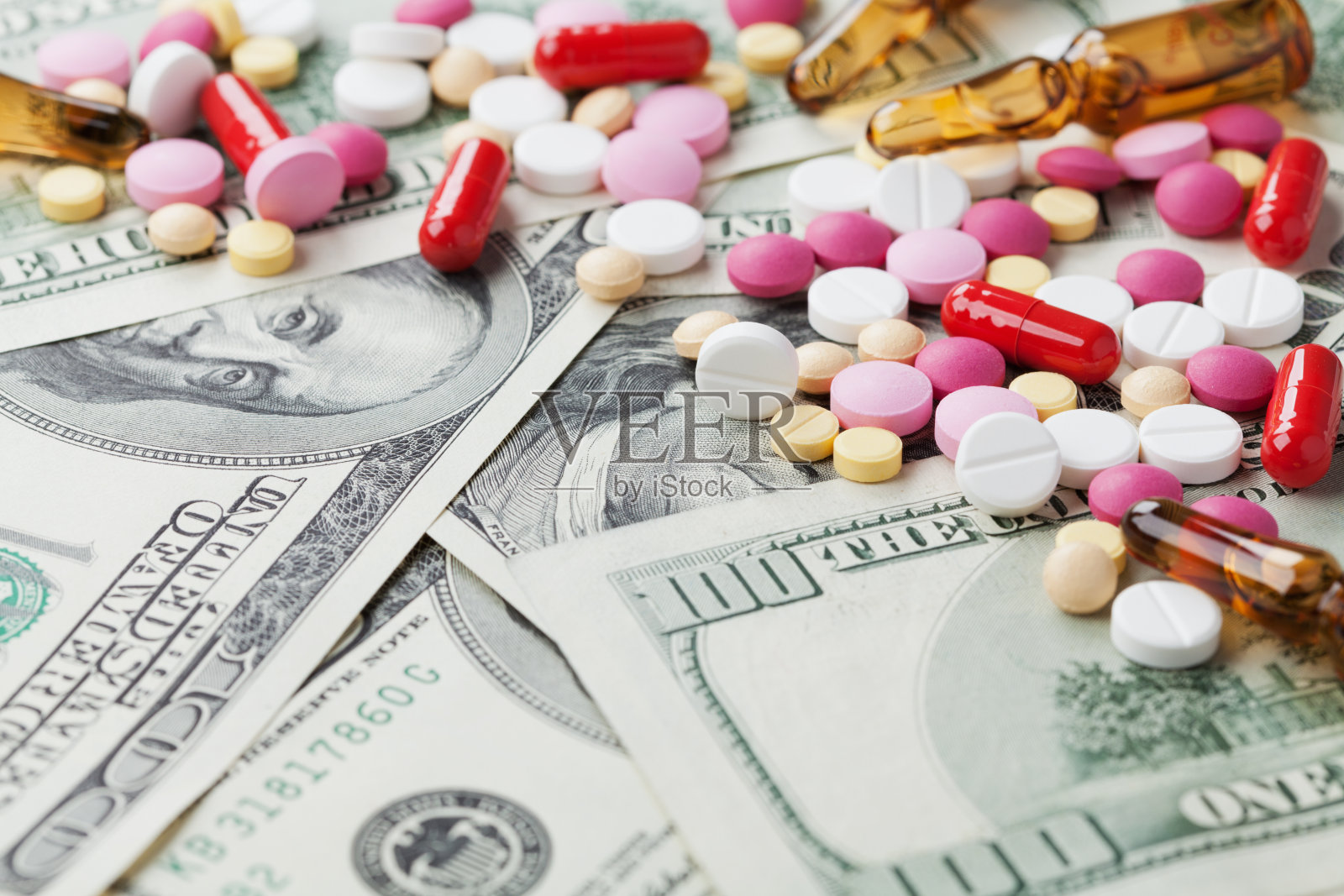药品成本和治疗理念，药丸片剂与现金照片摄影图片