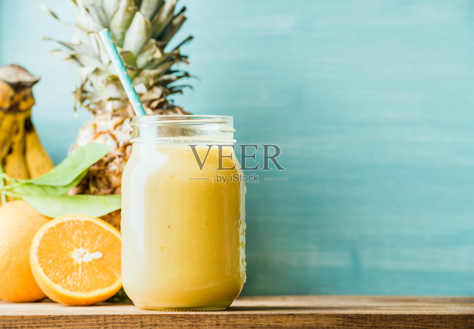 新鲜混合的黄色和橙色水果冰沙在玻璃罐照片摄影图片