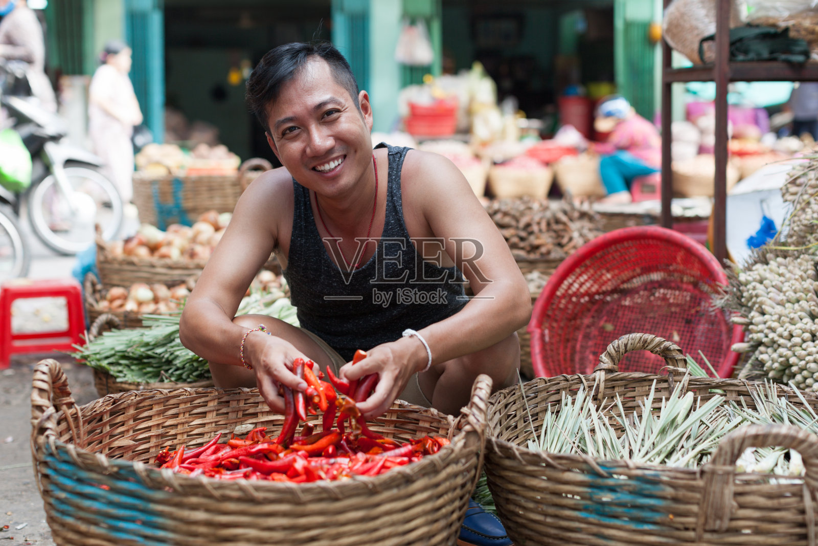 亚洲人在街头市场微笑卖红辣椒照片摄影图片
