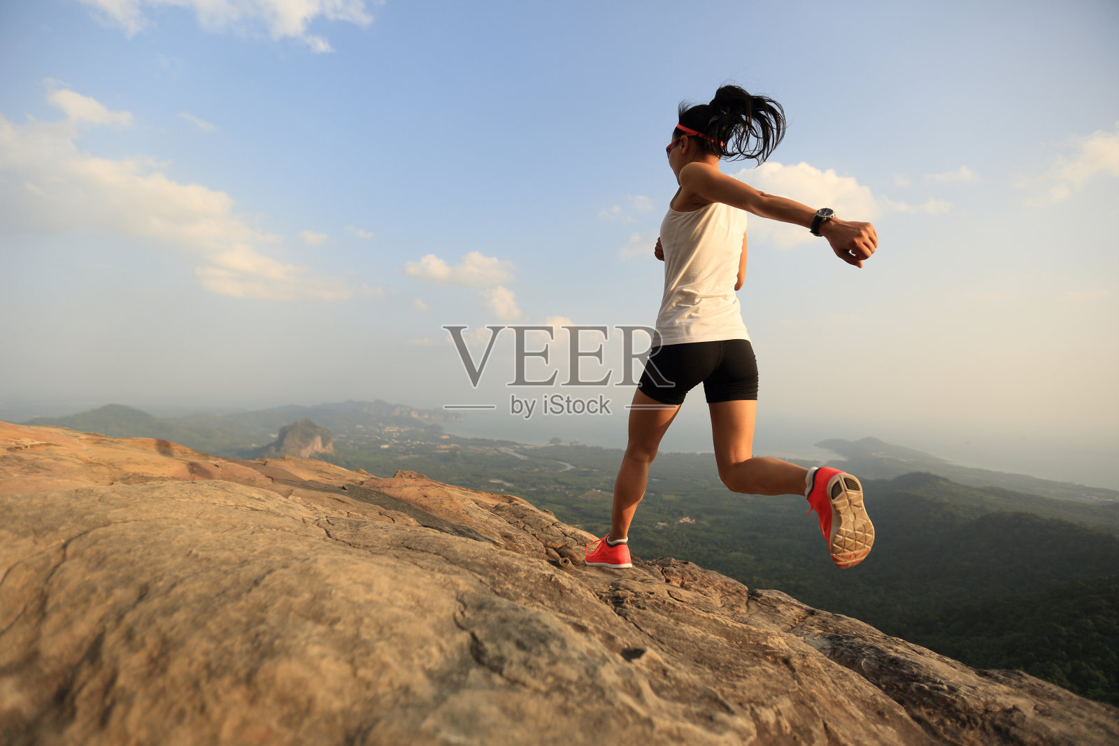 年轻女子在山顶上跑步照片摄影图片