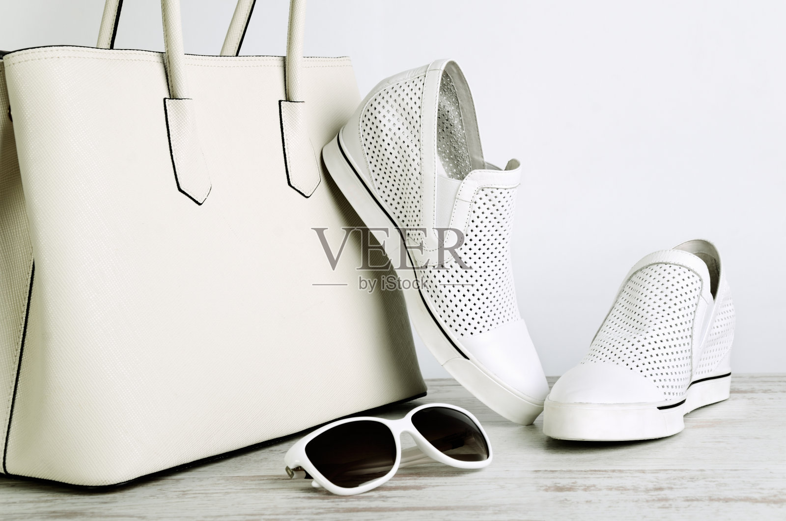 白色女士手袋，鞋子和太阳眼镜在灯光背景照片摄影图片
