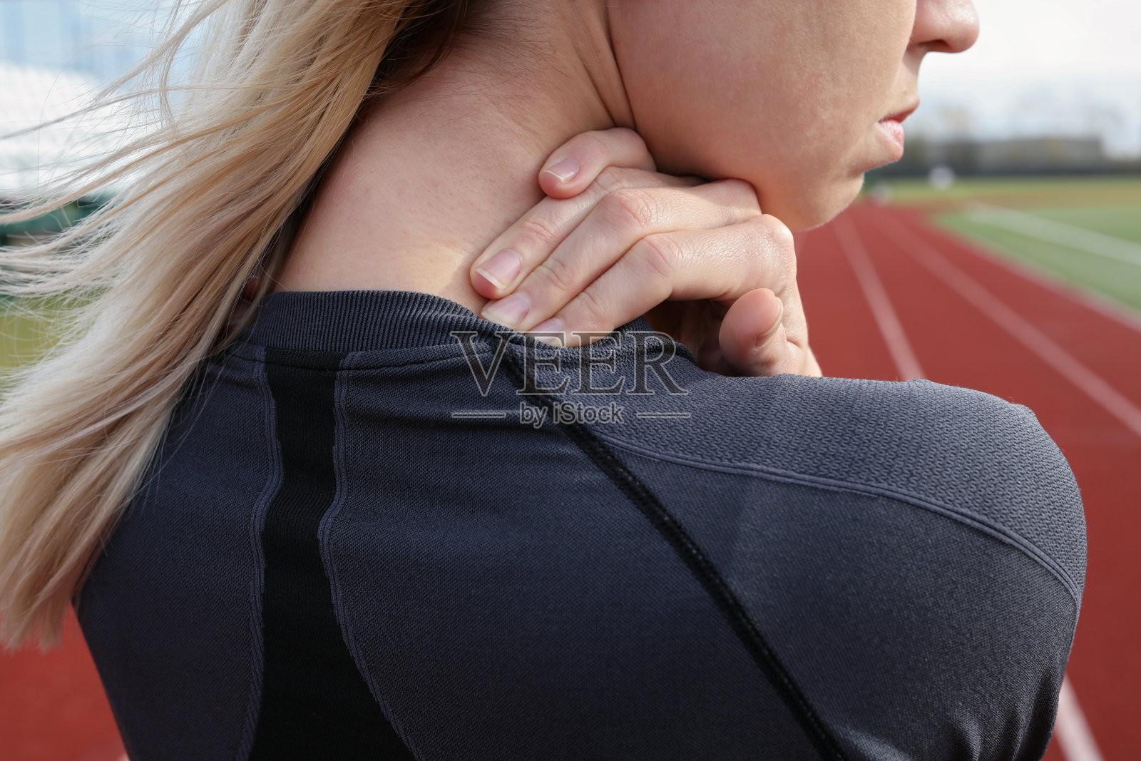 颈部疼痛。运动健身女人揉她的背。照片摄影图片