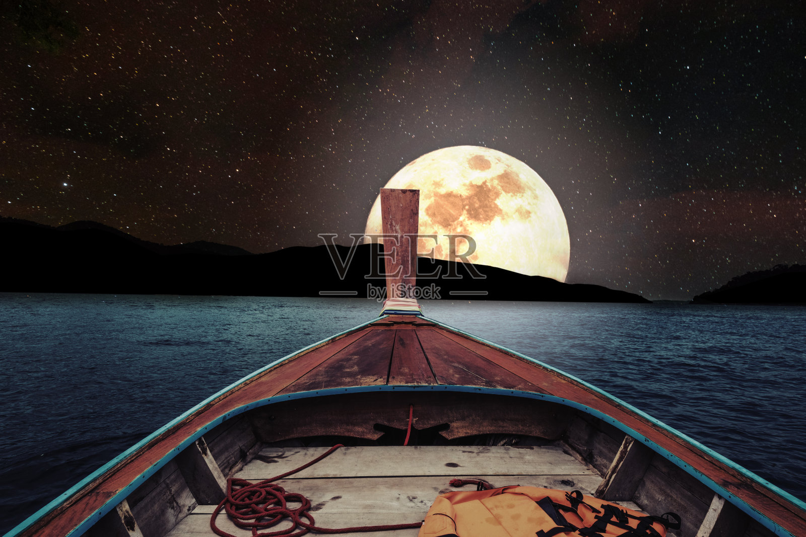 在满月的夜晚乘木船旅行照片摄影图片