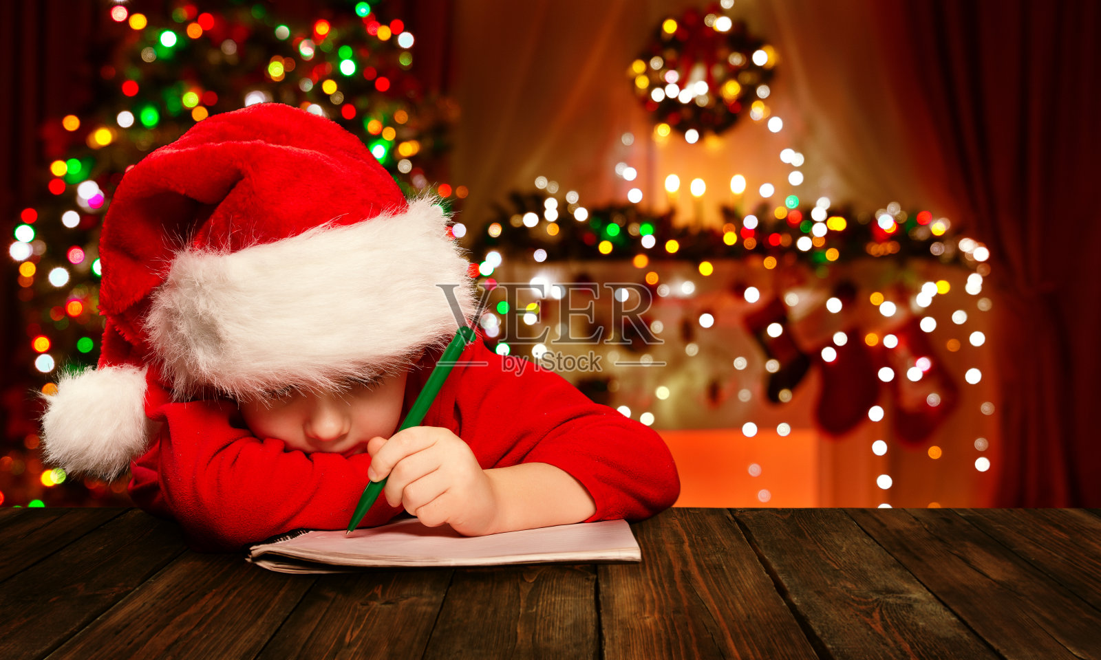 圣诞孩子写信给圣诞老人，孩子圣诞老人帽子写照片摄影图片