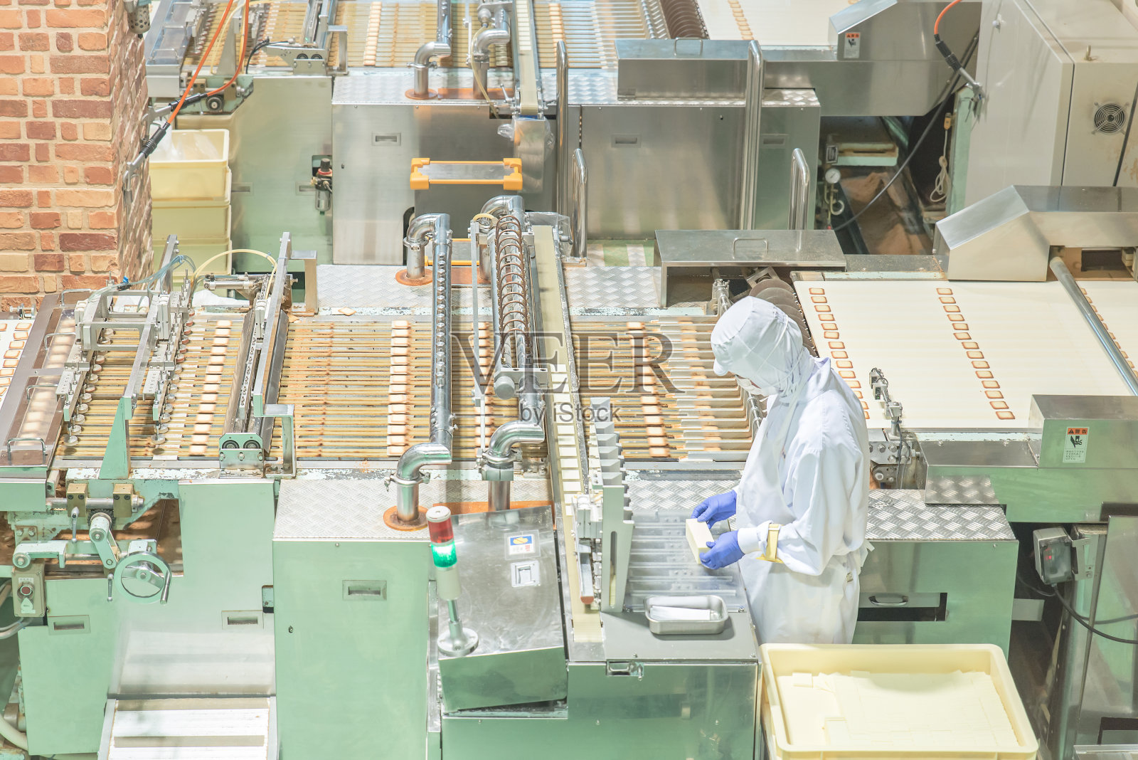 在饼干工厂和机器一起工作的工人照片摄影图片