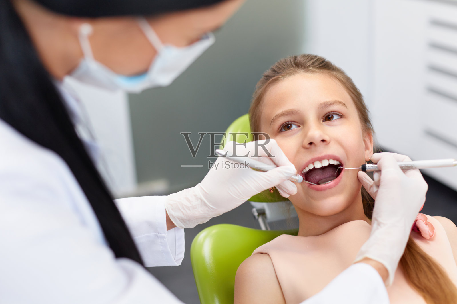 到牙科诊所进行牙齿检查。牙医检查女孩牙齿照片摄影图片
