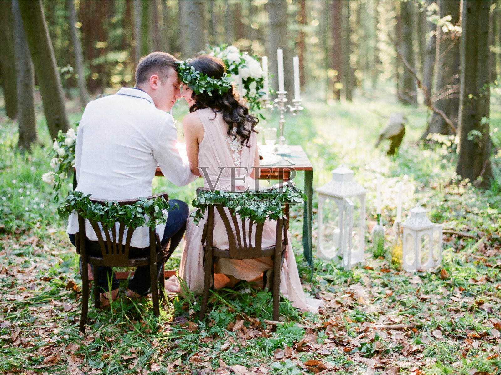 新郎和新娘坐在为两人准备的餐桌旁照片摄影图片