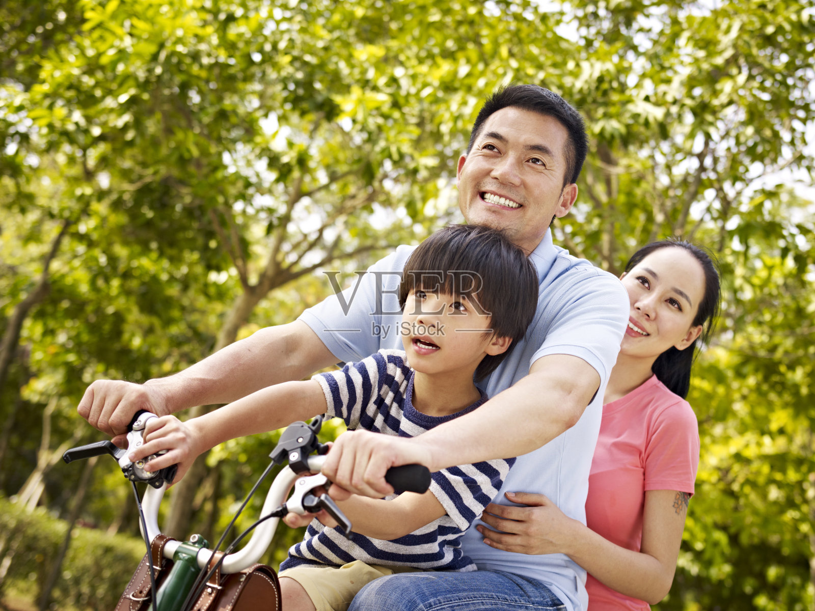 亚洲家庭在公园里骑自行车照片摄影图片