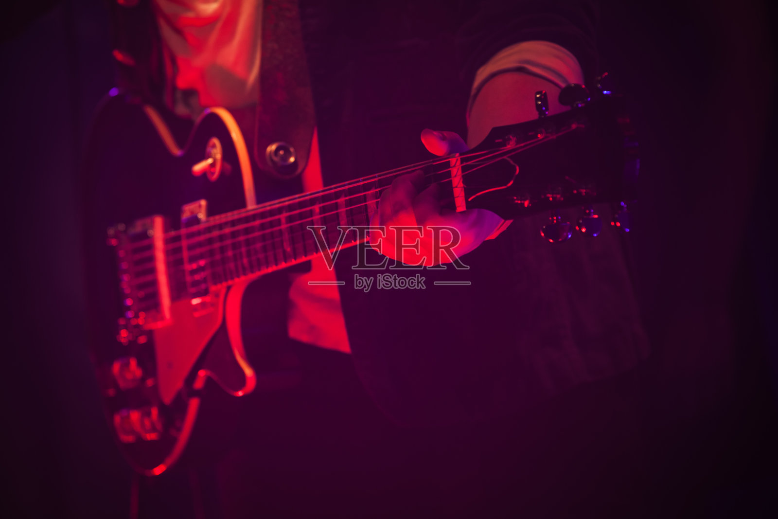 红色灯光下的舞台上有吉他手照片摄影图片