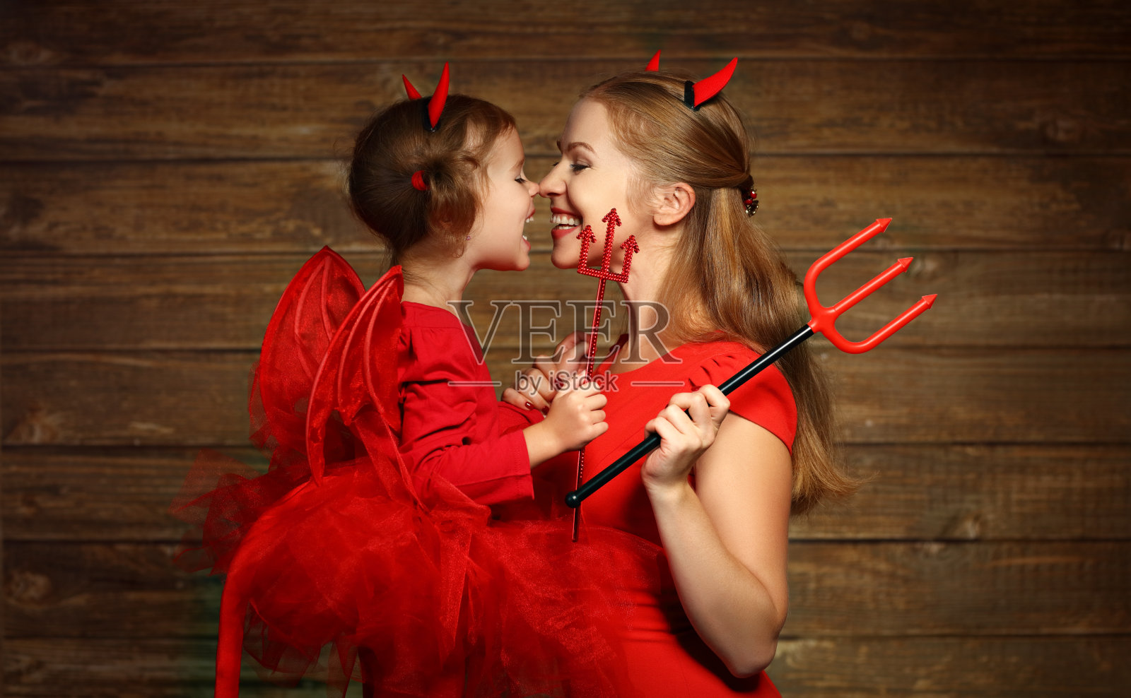 家庭母亲和孩子的女儿庆祝万圣节在魔鬼公司照片摄影图片
