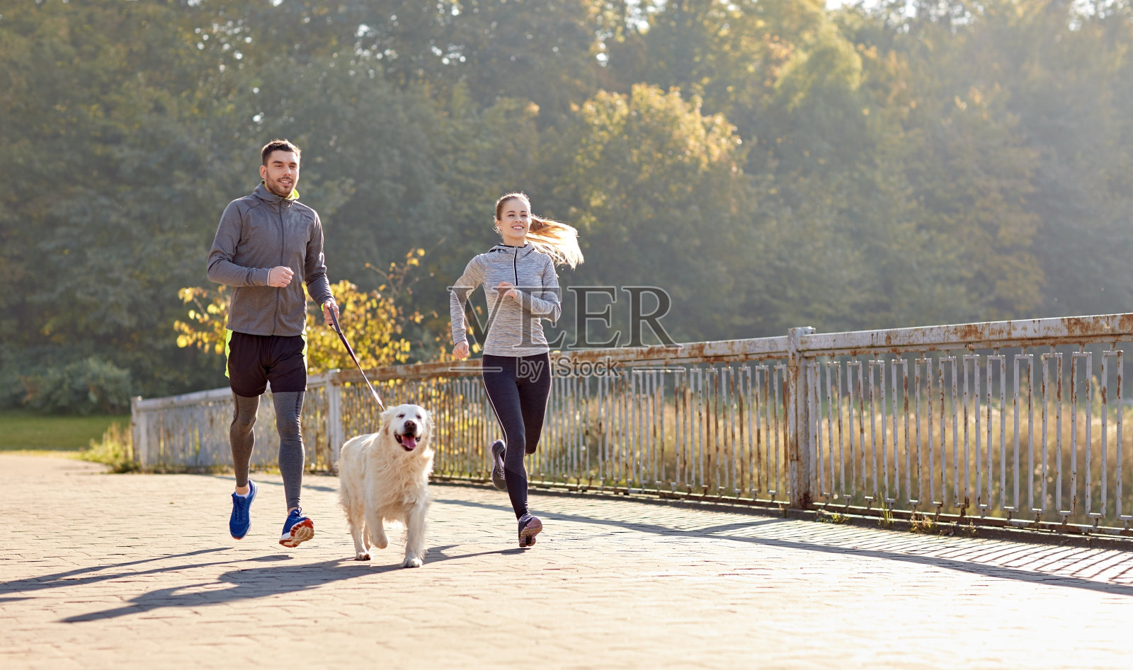 幸福的夫妇和狗在户外跑步照片摄影图片