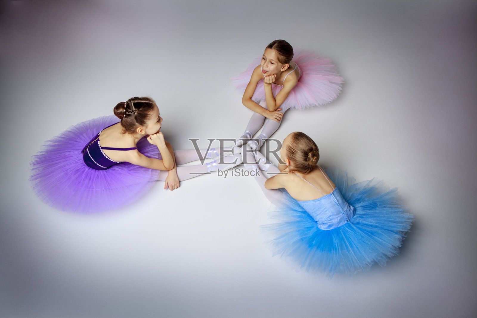 三个芭蕾舞小女孩穿着芭蕾舞裙坐在一起摆姿势照片摄影图片