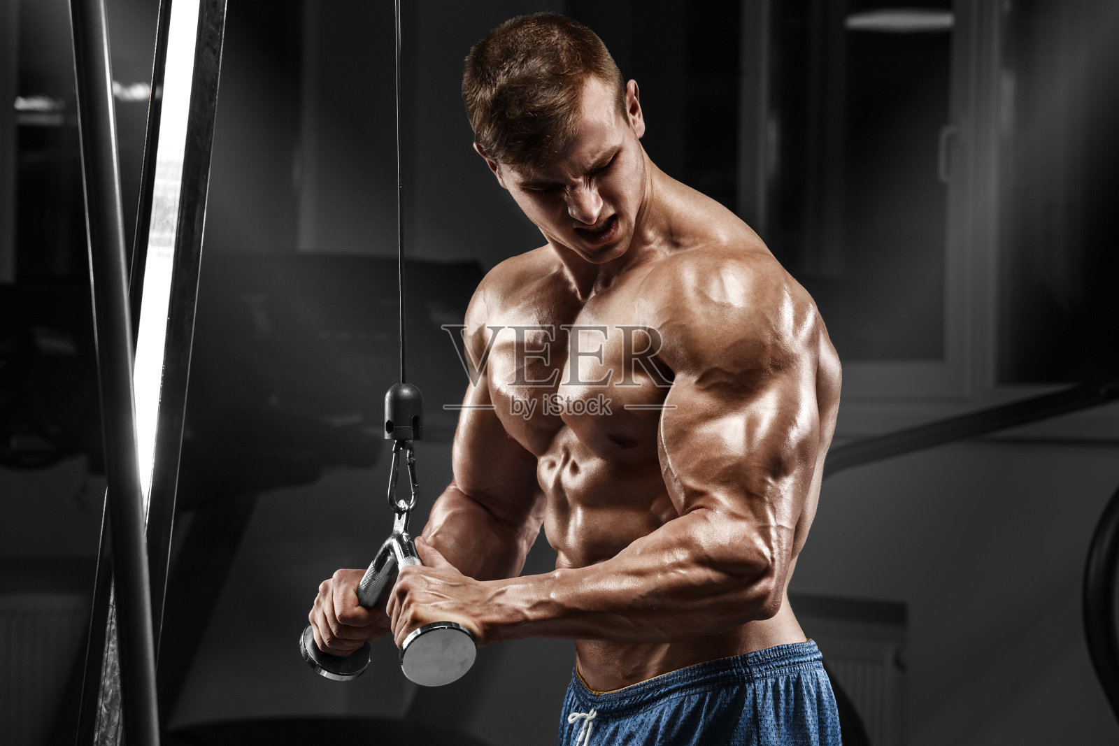 肌肉男在健身房锻炼身体，躯干有腹肌照片摄影图片
