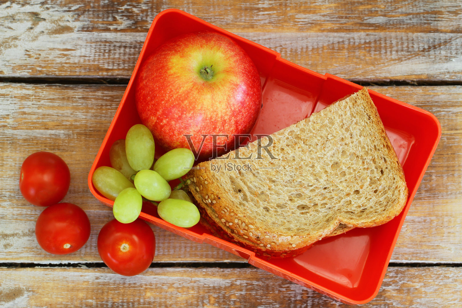 午餐盒，有黑面包三明治，苹果，葡萄和西红柿照片摄影图片