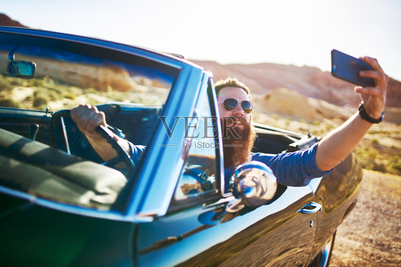 有胡子的家伙在老爷车里自拍炫耀照片摄影图片