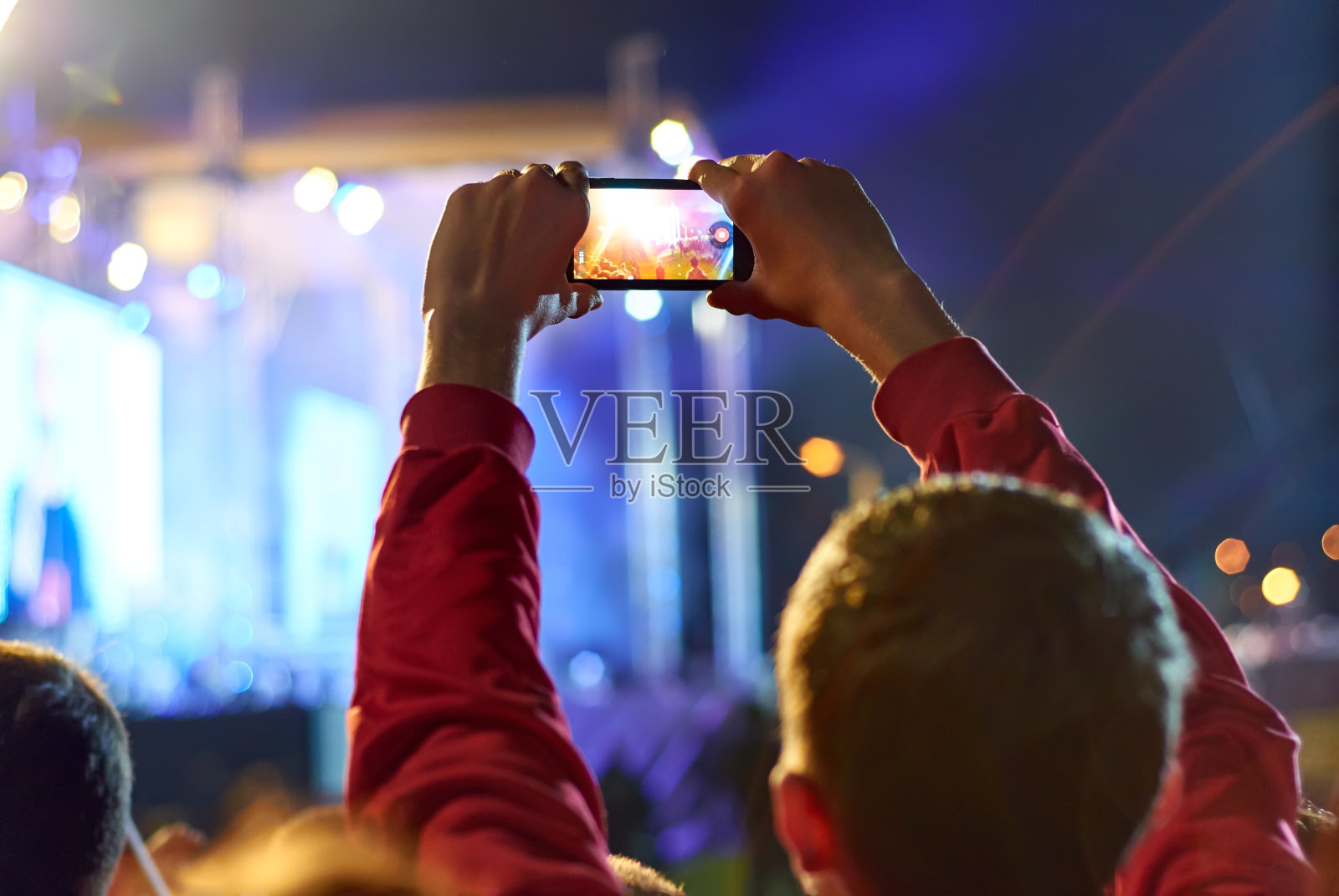 在音乐会期间用智能手机录制视频的特写。照片摄影图片