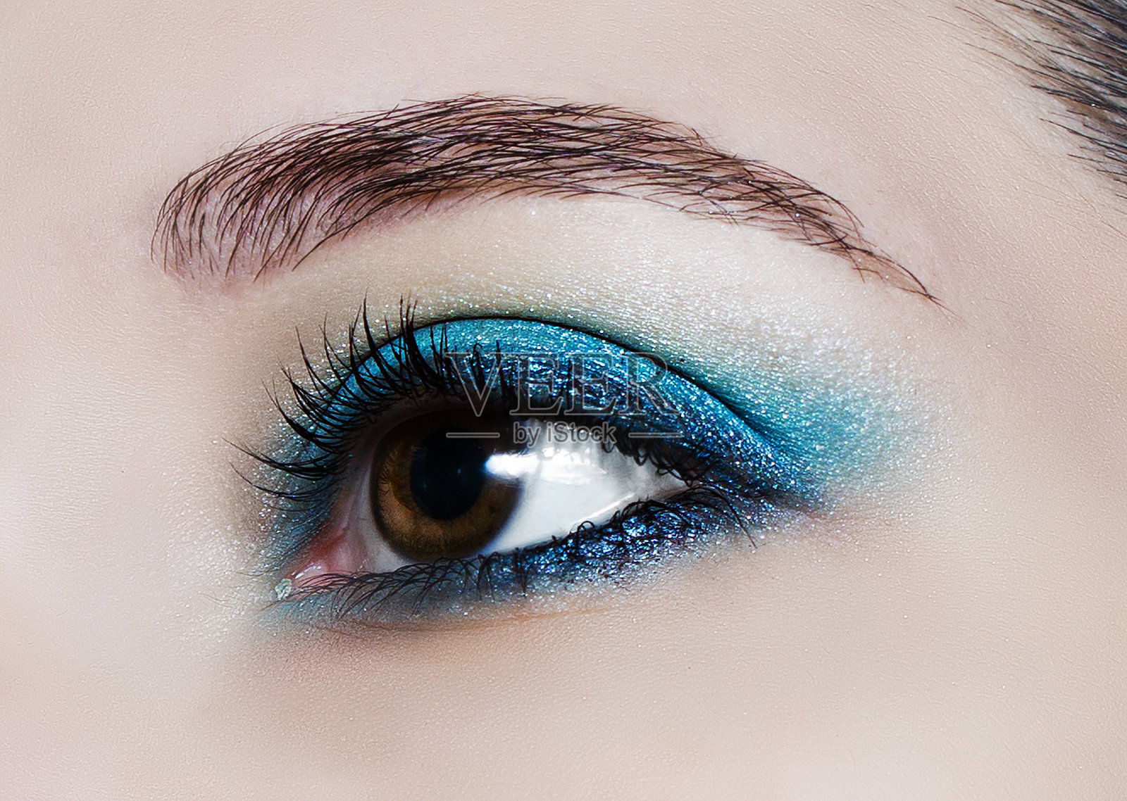 化妆趋势:蓝色闪亮的眼影。照片摄影图片