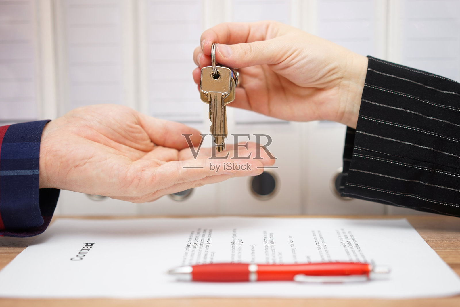 房产卖家在签字后将钥匙交给买家照片摄影图片