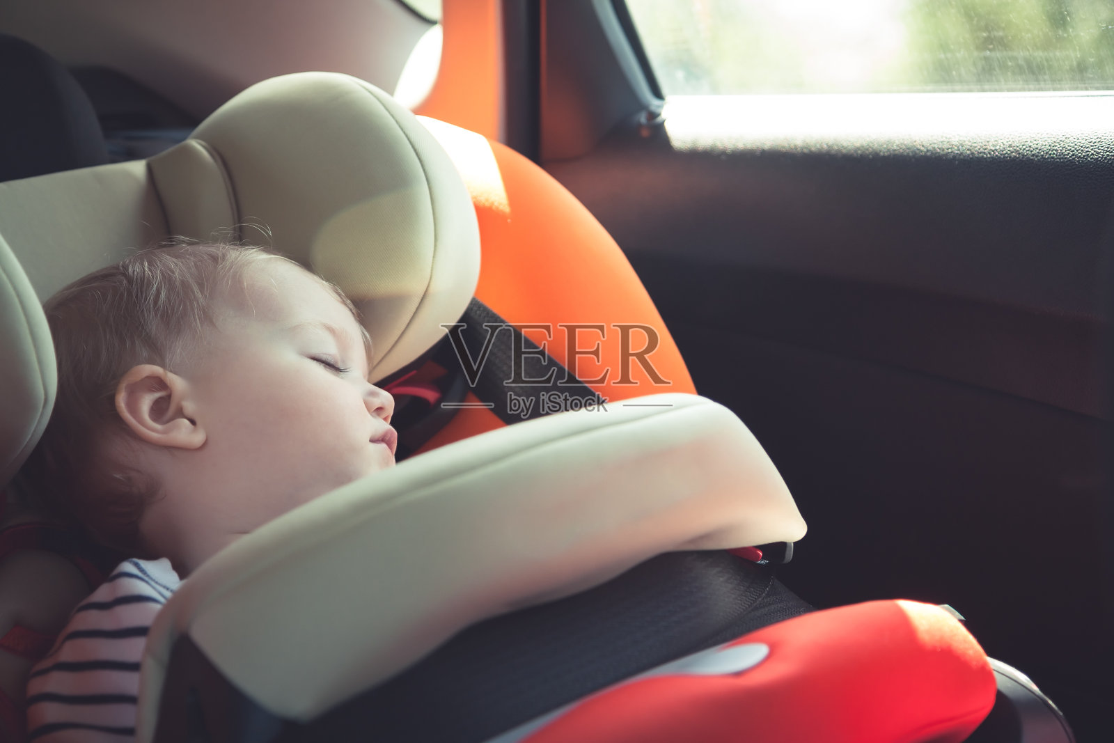 旅行时婴儿睡在汽车安全座椅上照片摄影图片