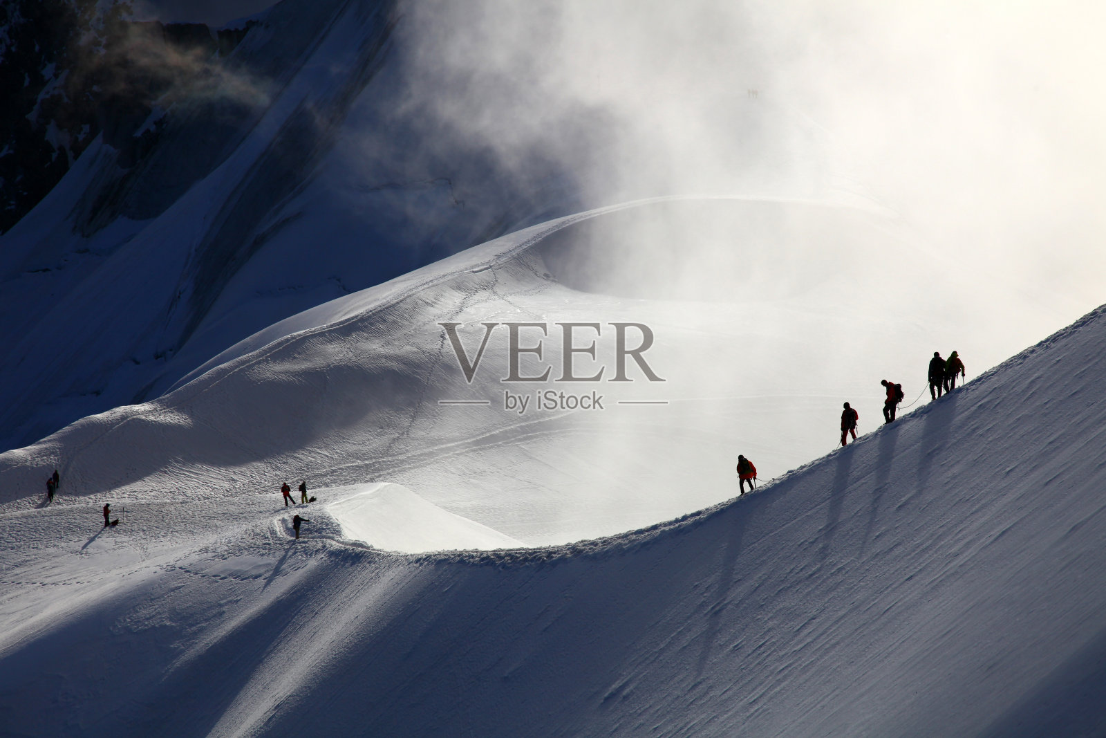 登山运动员在雪堆中前进照片摄影图片