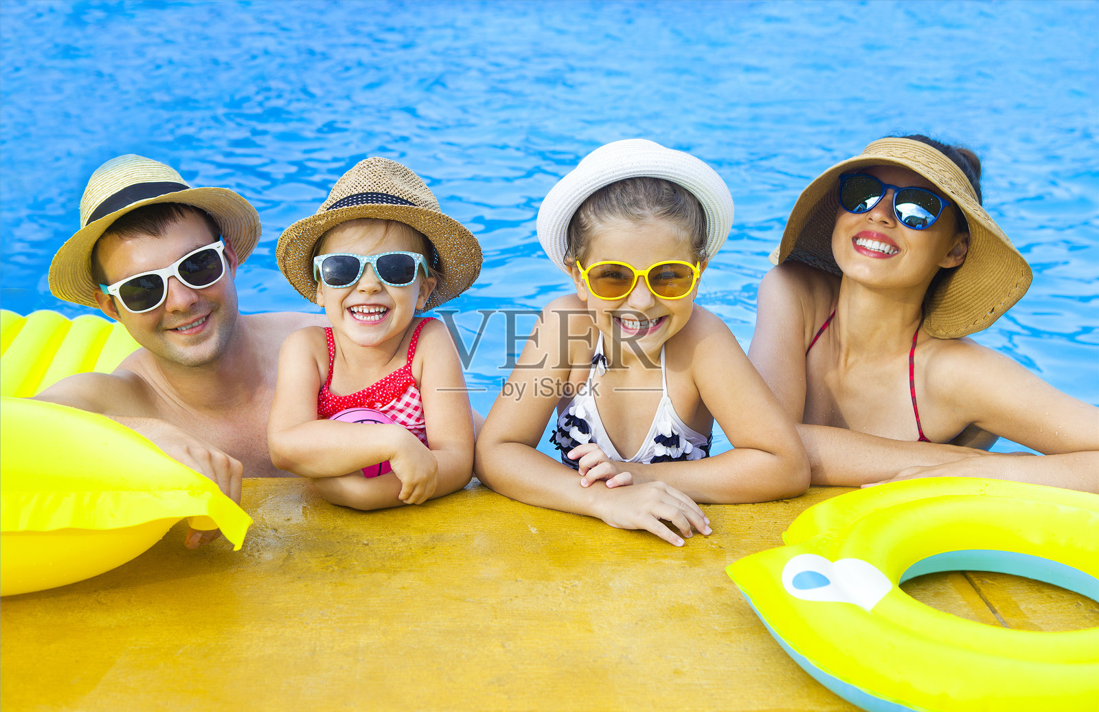 幸福的家庭和两个孩子在游泳池里玩照片摄影图片