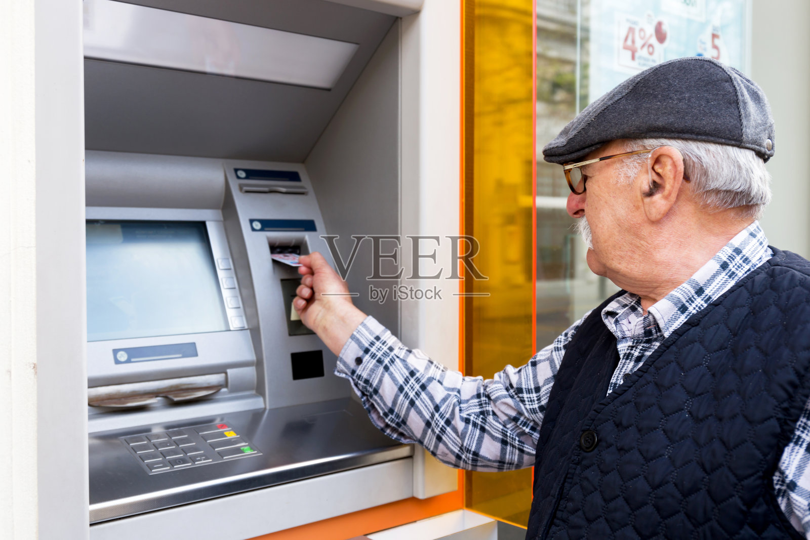 将信用卡插入自动取款机的老人照片摄影图片