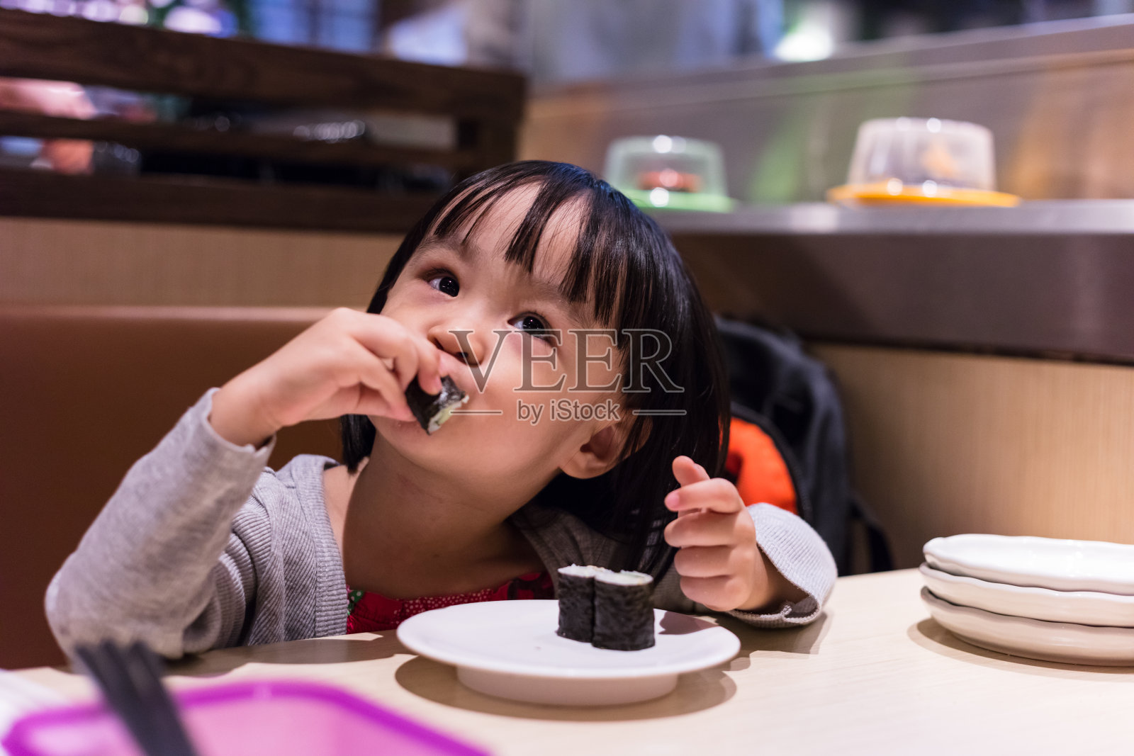亚洲华人小女孩在日本餐厅吃寿司照片摄影图片