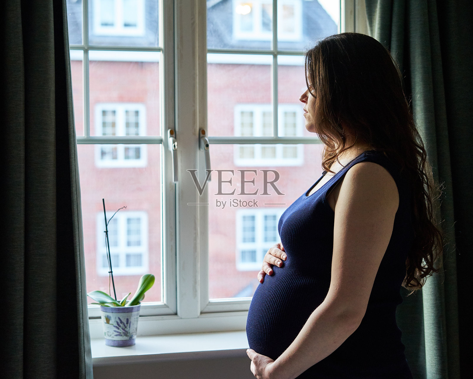 孕妇肖像在英国的窗户前。照片摄影图片