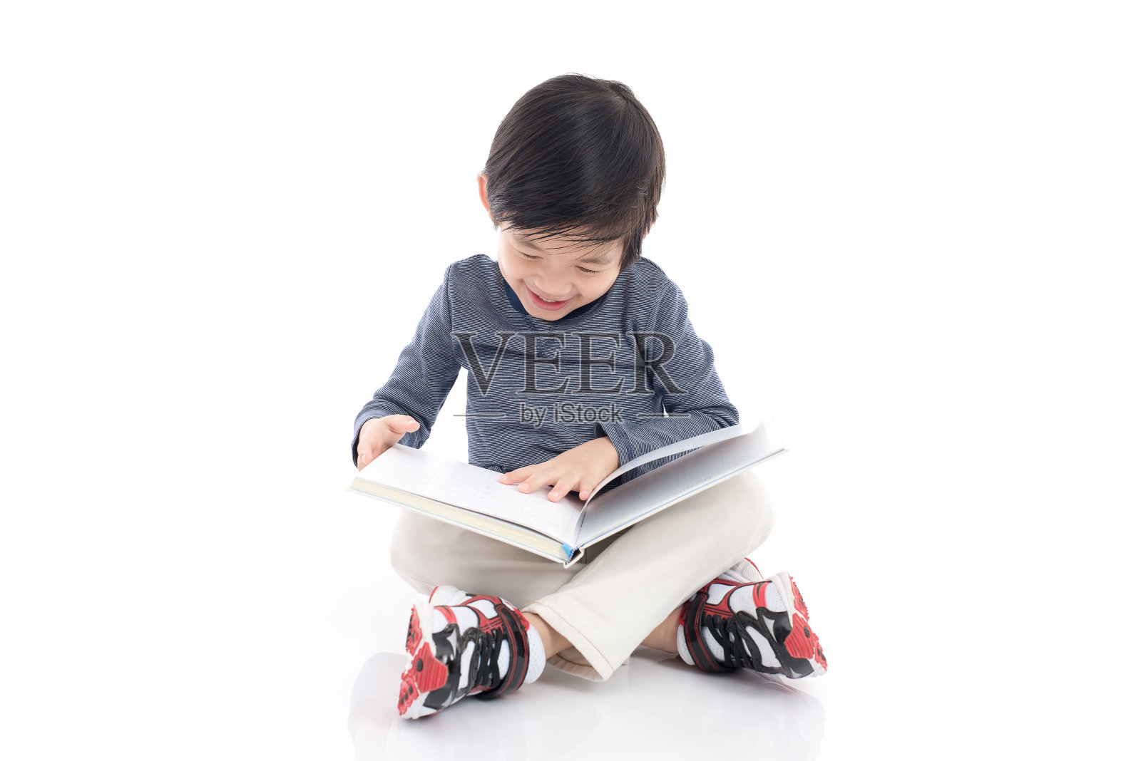 可爱的亚洲男孩读一本关于白人背景孤立的书照片摄影图片