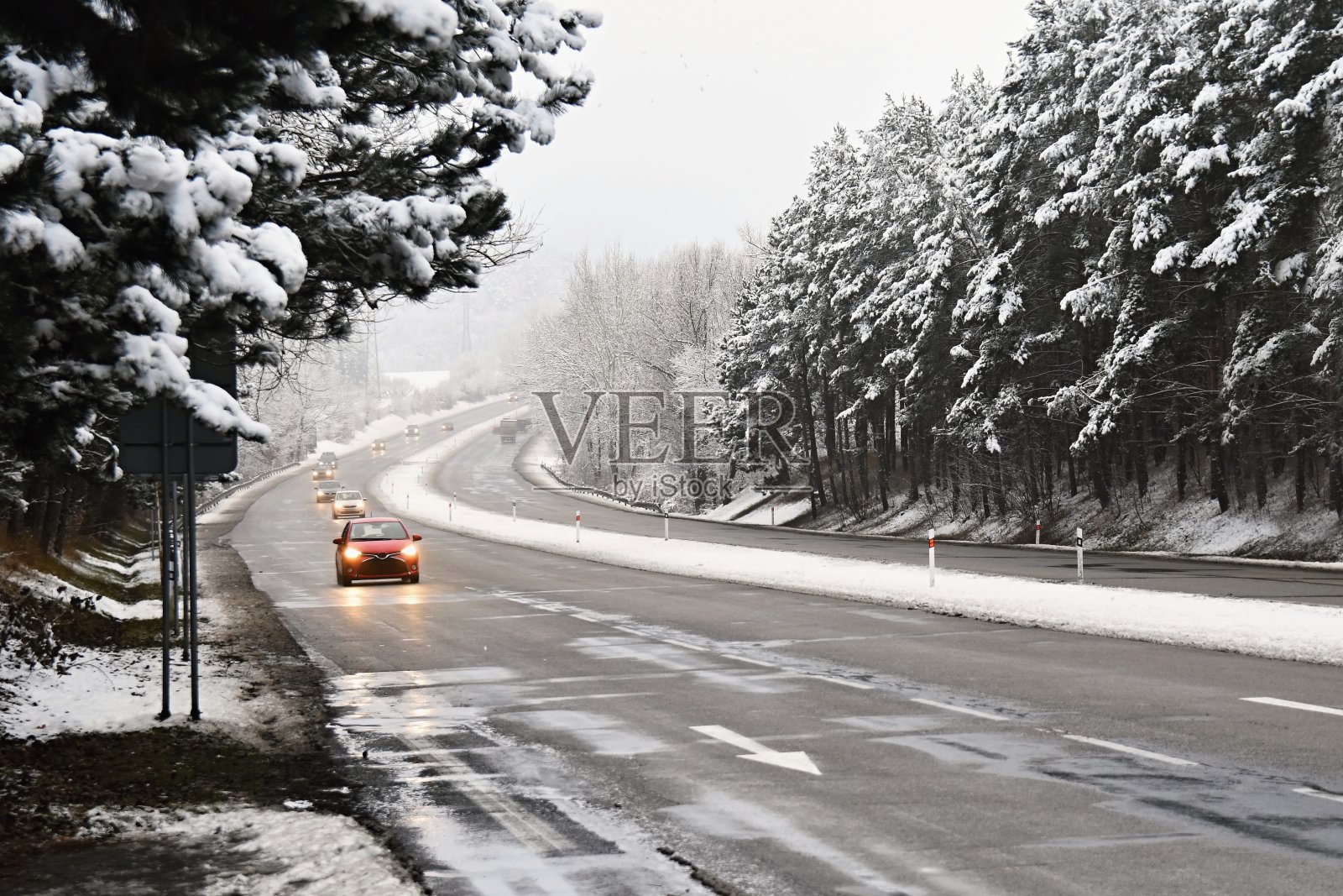 汽车在冬天的雪地上行驶。恶劣天气下的交通十分危险照片摄影图片