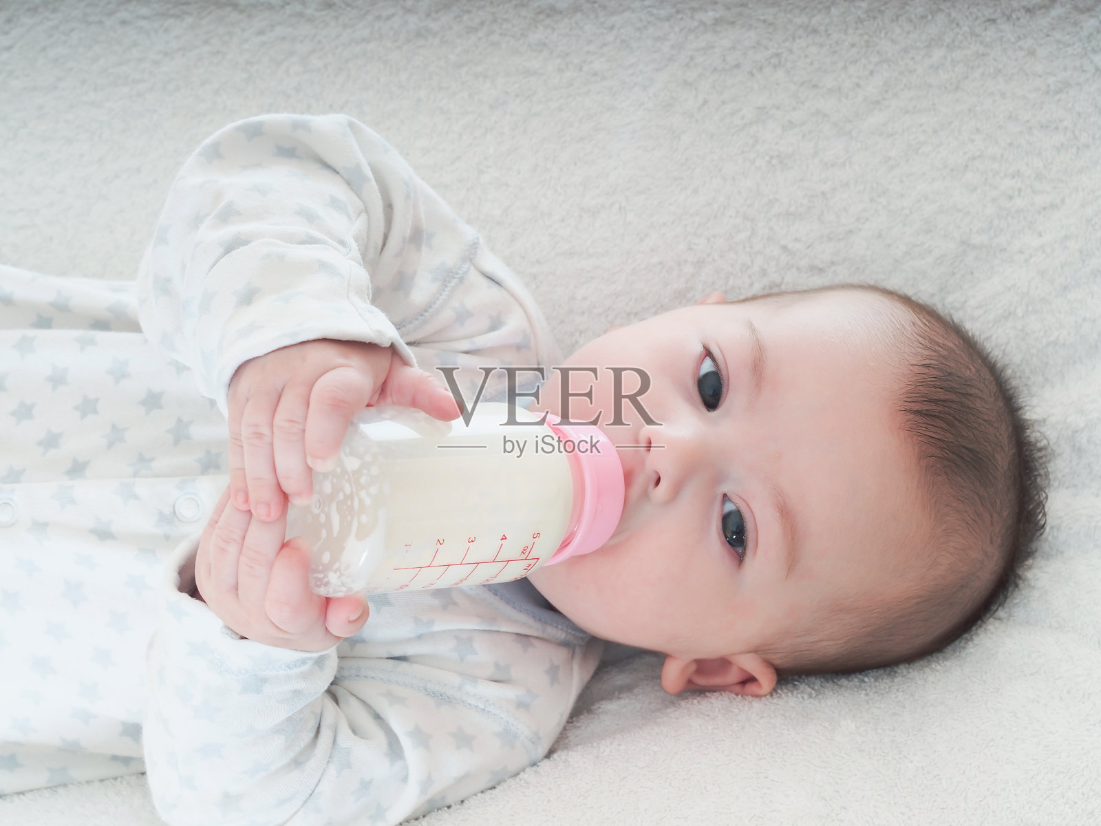 小男孩在家喝奶瓶里的牛奶照片摄影图片
