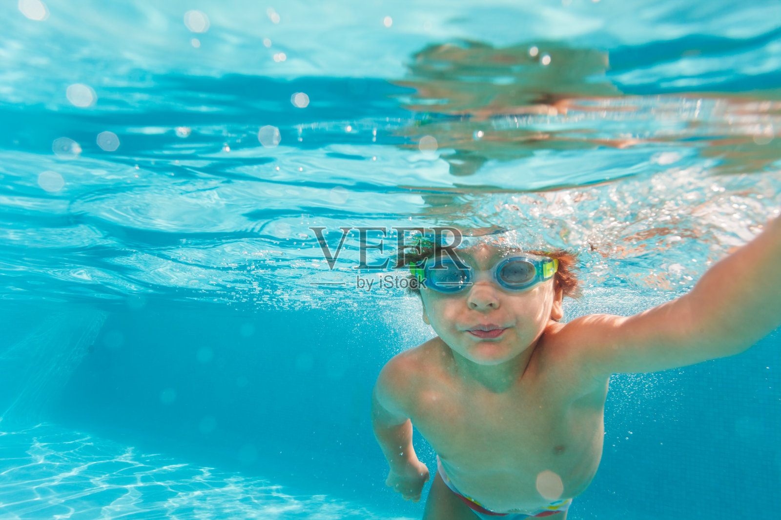 小男孩戴着护目镜在水下游泳照片摄影图片