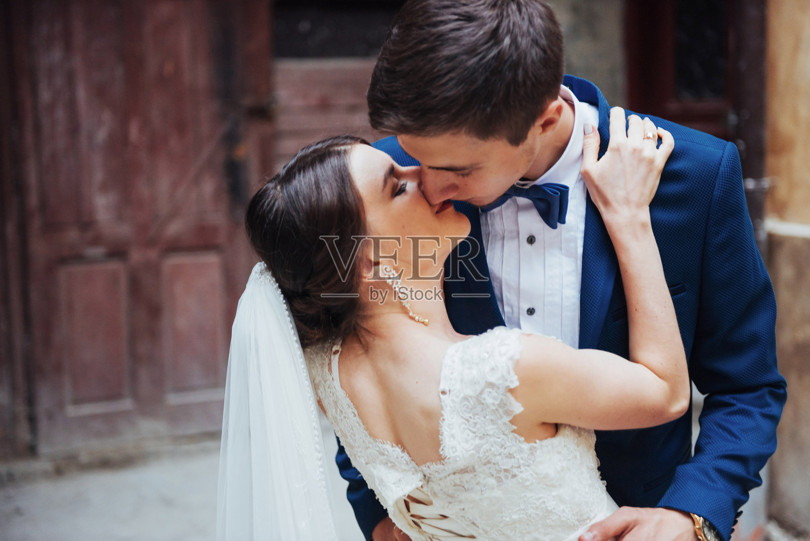新婚夫妇的结婚照。站和亲吻照片摄影图片