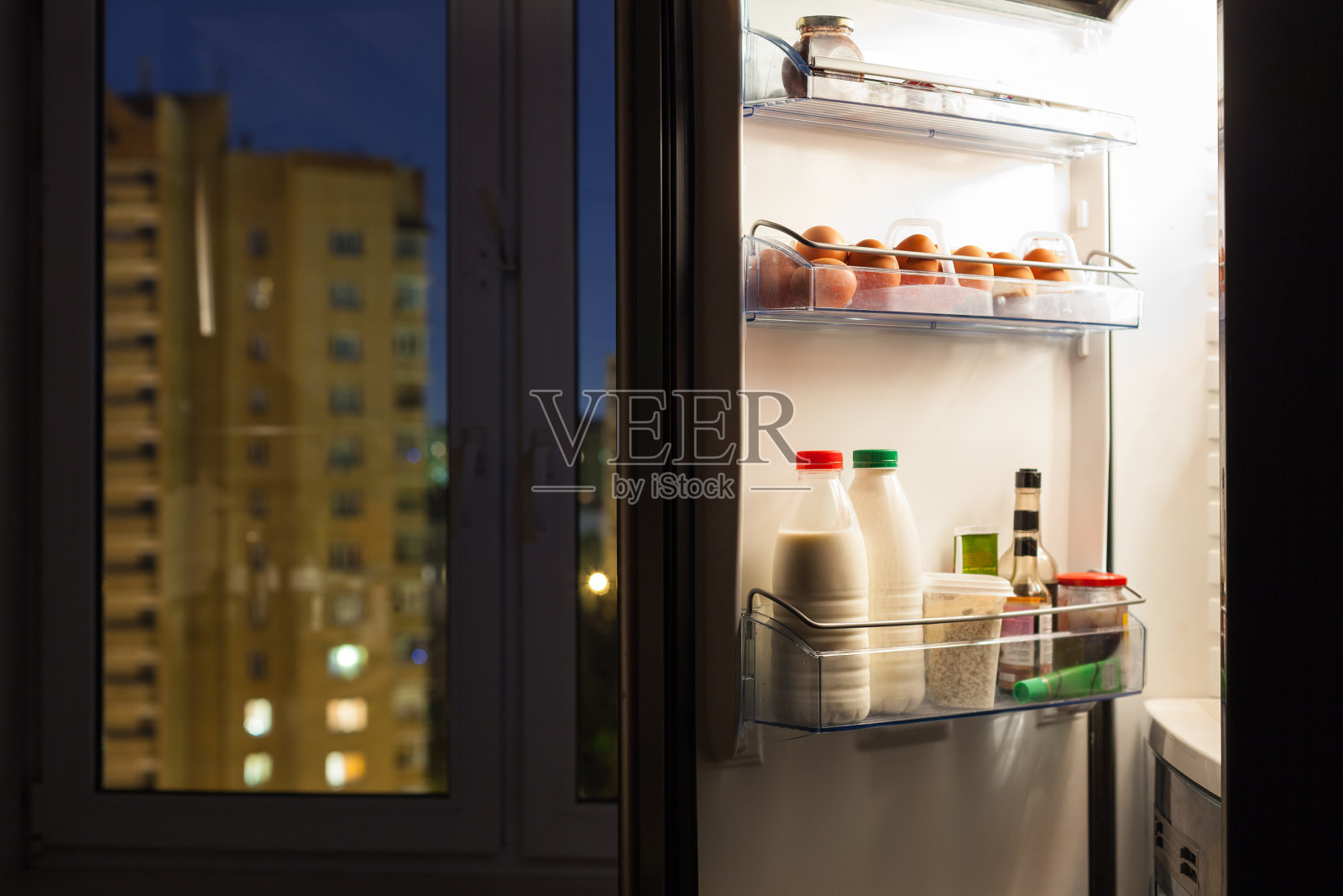 家庭冰箱门与乳制品在晚上照片摄影图片