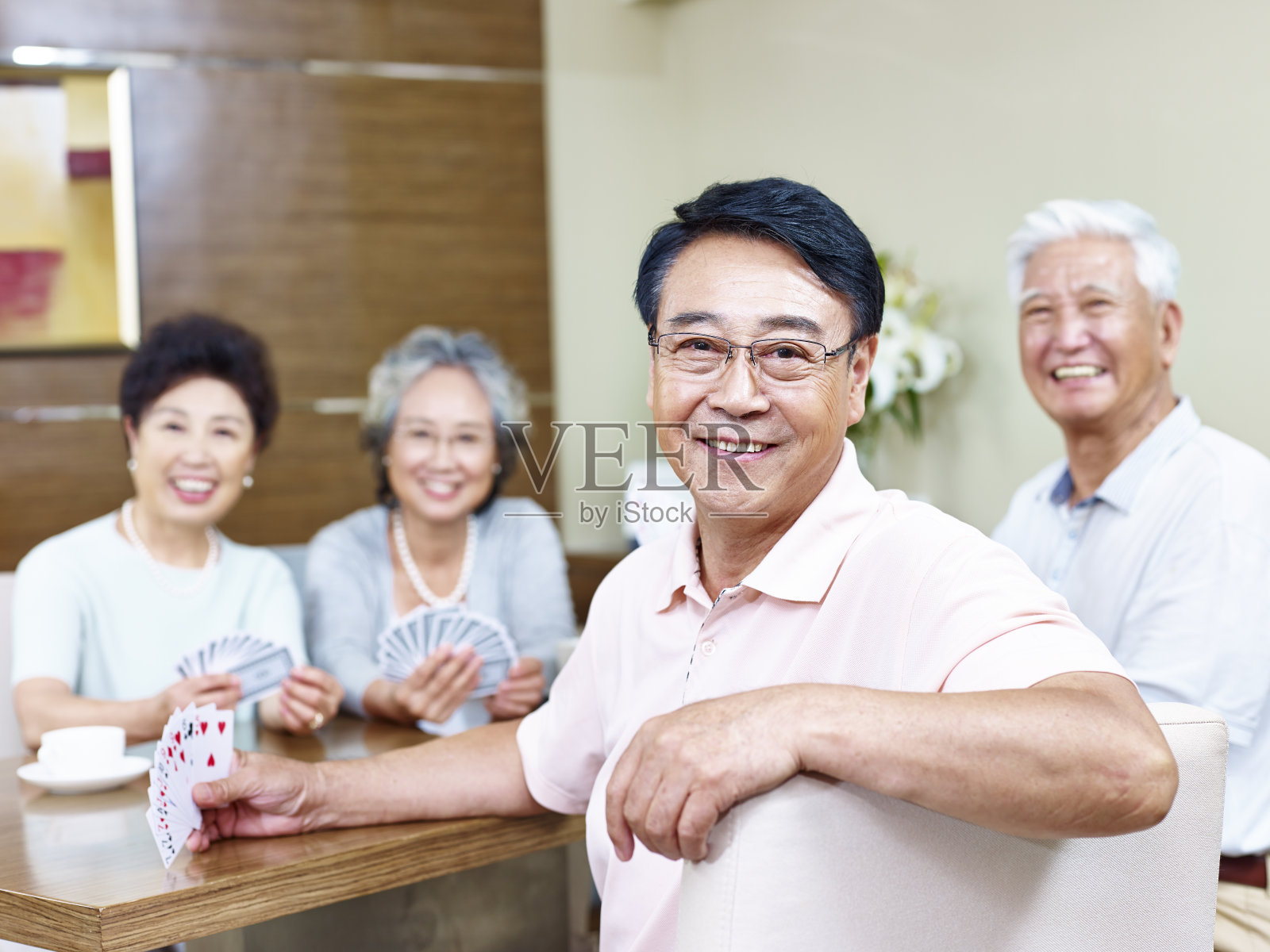 年长的亚洲人在和朋友打牌照片摄影图片