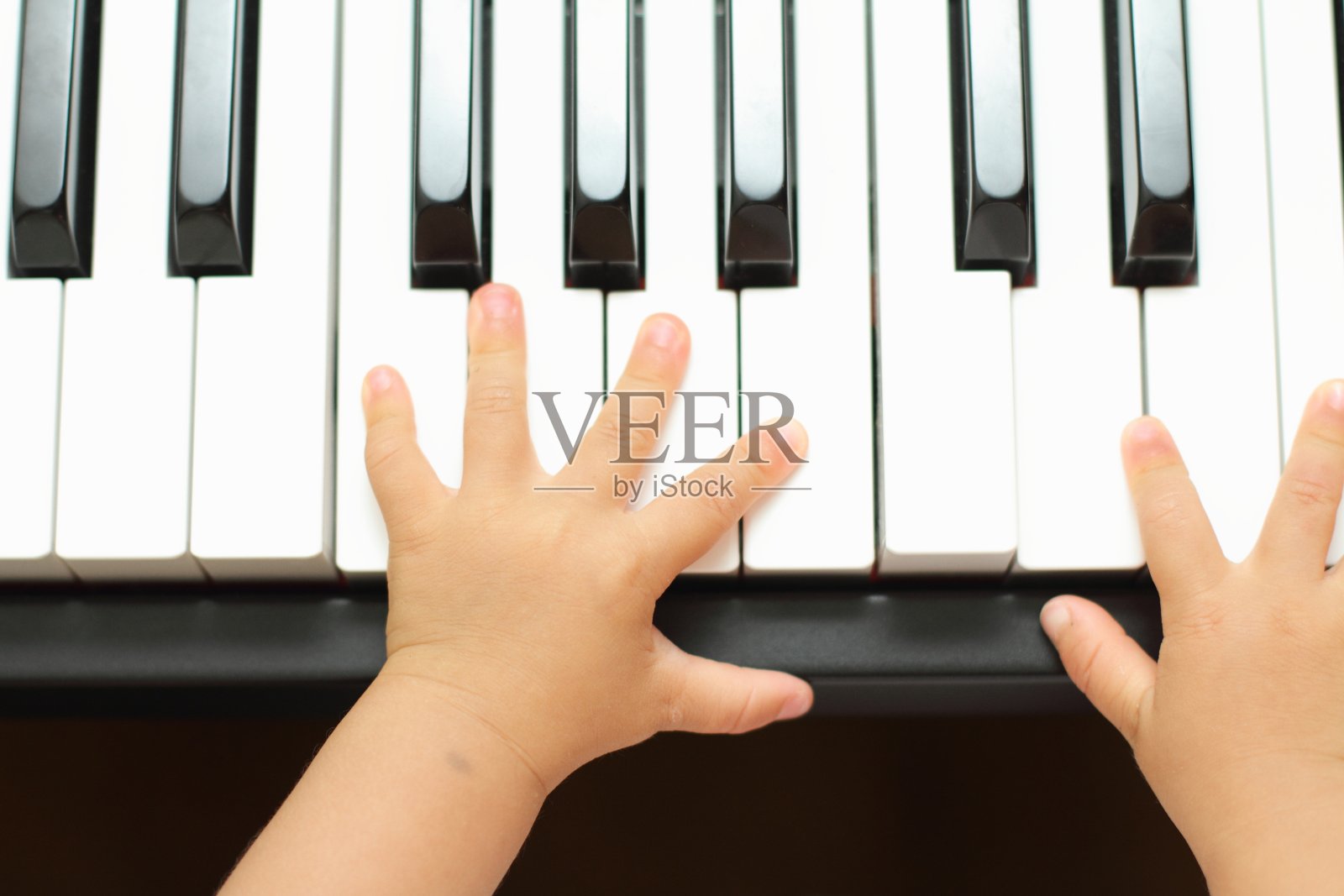 日本女孩弹钢琴的手(1岁)照片摄影图片