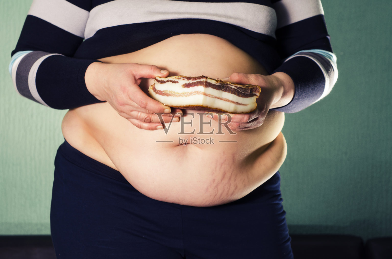 超重，肥胖的女人拿着培根照片摄影图片