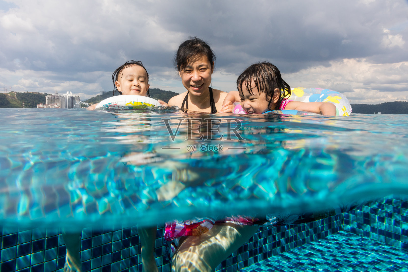 亚洲华人家庭在室外游泳池玩照片摄影图片