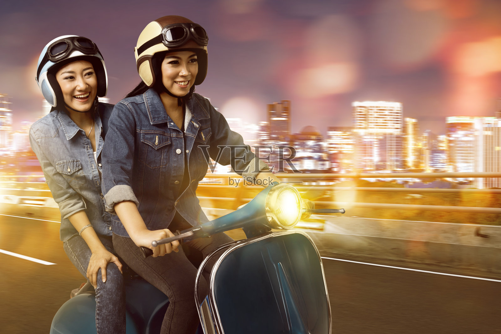 快乐的两个年轻的亚洲女人骑摩托车玩得很开心照片摄影图片