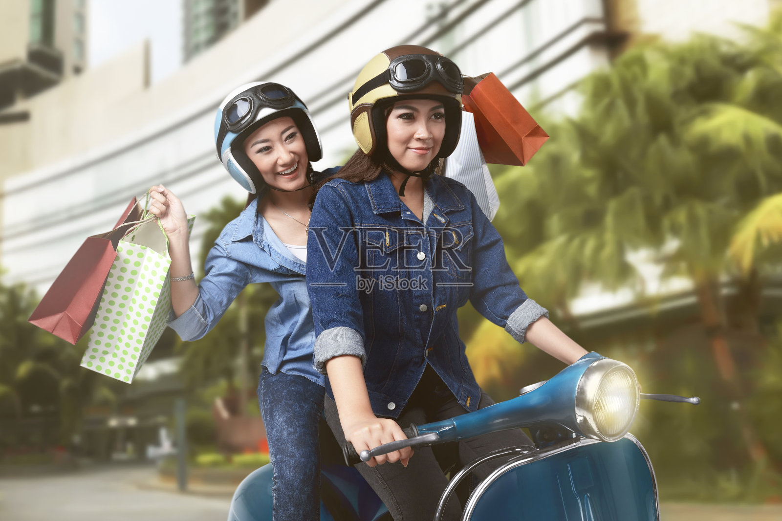 快乐的两个亚洲女人在购物后骑摩托车照片摄影图片