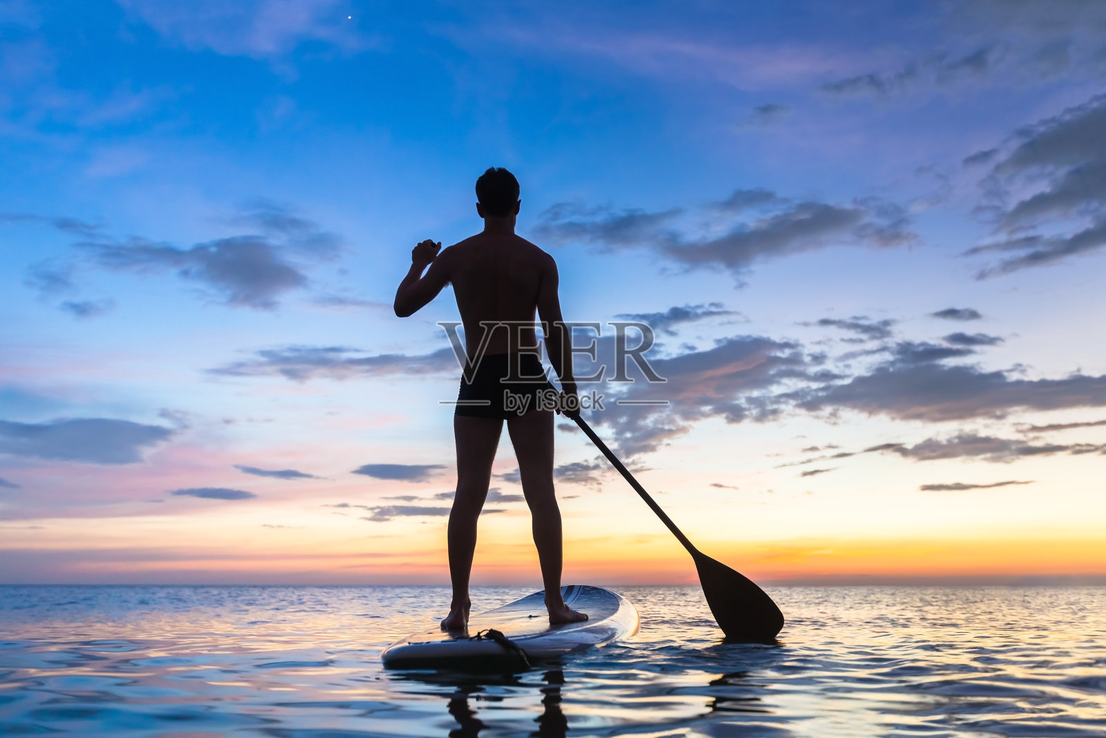 站起来划桨的剪影，在日落，大海照片摄影图片