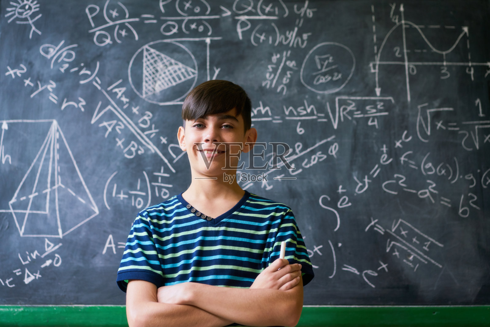 在数学课上，自信的拉丁男孩对着摄像机微笑照片摄影图片